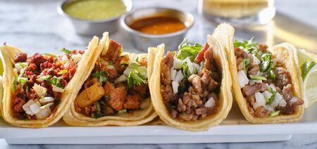 platter of mexican street tacos with carne asada, chorizo, and al pastor in corn tortillasの写真素材