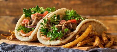 two greek gyros with fries, tomato and lettuceの写真素材