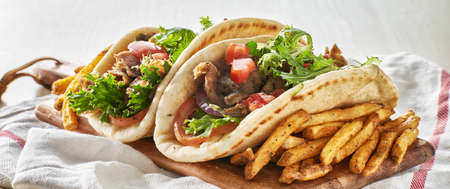 two greek gyros with fries, tomato and lettuceの写真素材