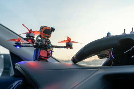 fpv drone lies switched on on the panel of the car under the windshield control panel blue and red lights are on propellers flight nature winterの写真素材