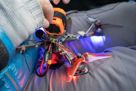 connection of the drone kneeling hands mens blue jacket red and blue light bulbs propellers fpv...