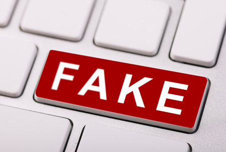 Word Fake on red button on white keyboard. Close-up.の写真素材