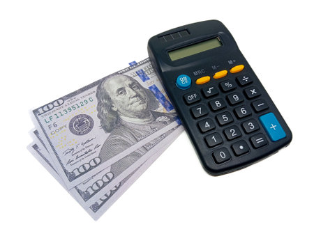 US $100 bills fanned out next to a dark-colored basic calculator, isolated on a clean white background, signifying financial calculation or budgetingの写真素材
