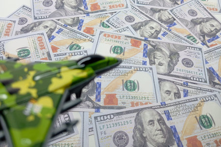 A blurred foreground shows a green camouflage toy airplane, pointing towards a scattered background...