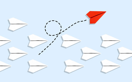 Red paper plane flying in a different direction from a group of white paper planes.の写真素材