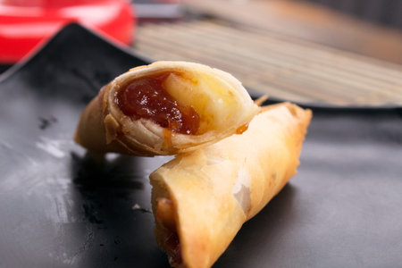Brazilian Guava Dessert with cheese harumaki on black plate. Spring roll.