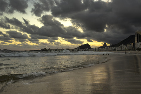 Rio de Janeiro, Brazil - March 29, 2019: Sunset View in Copacabana Beach with Mountains in Horizon and Tall Hotel Building, Rio de Janeiro, Brazilのeditorial素材