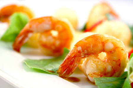 Delicious fried shrimp decorated with basil on the white plateの写真素材