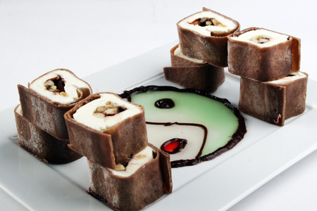 Sweet chocolate roll with fruits and philadelphia cheese in mint sauceの写真素材