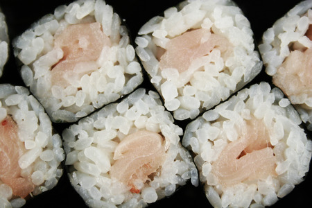 Sushi roll with perch and garnish on plack plateの写真素材