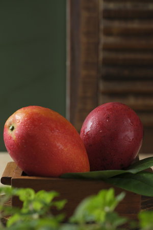Red mangoes on wooden container. Buah Manggaの写真素材