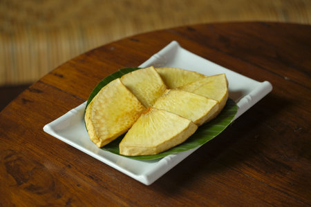 A plate of Fried Breadfruit on round table. Sukun goreng