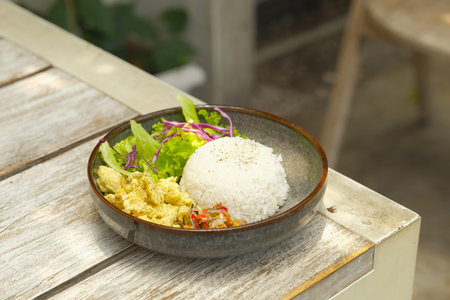 Rice bowl with scramble egg, lettuce and purple cabbage also sambal matah. Delicious menu for lunch on the tableの写真素材