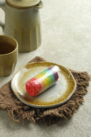 Rainbow roll cake on rustic brown with gray background