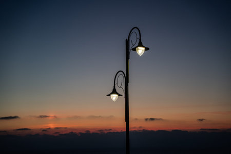 Public street lighting pole with LED lights with sunset color background.