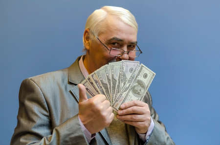 Business man with a bundle of money enjoys a successful deal.の写真素材