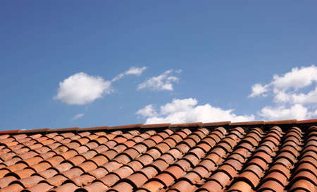 A roof on a large residential construction site leads to a blue sky with clouds.の写真素材