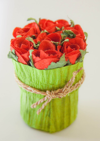 bundle of red roses in paper bagの写真素材