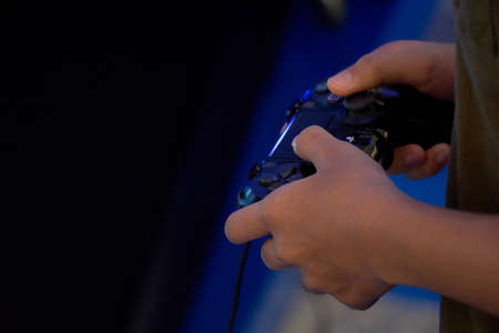 Close up of a kid holding black game controllerのeditorial素材
