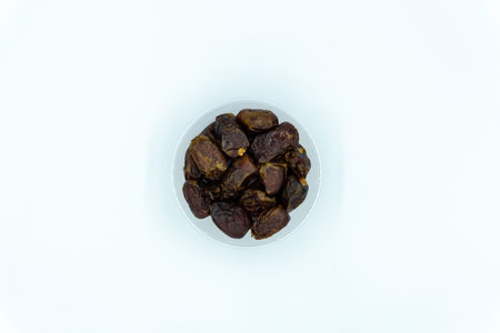 Dates in a large plastic container over white background