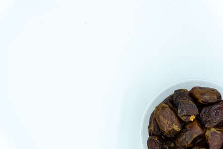 Dates in a large plastic container over white backgroundの写真素材