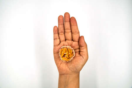 Single honey cornflakes on top of the hand over white backgroundの写真素材