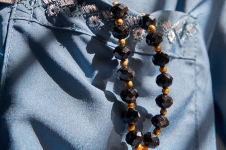 Black colored prayer beads in the blue shirt pocketの写真素材