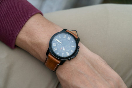 Unidentified asian man wearing black watch with brown leather strap