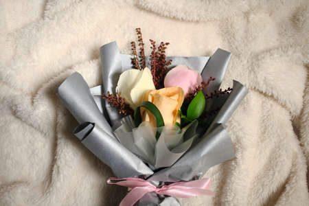 Bouquet of white, yellow and pink roses over white clothの写真素材