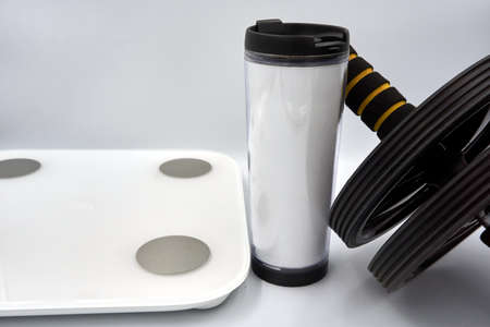 Digital weight scale, tumbler and abs roller over white backgroundの写真素材