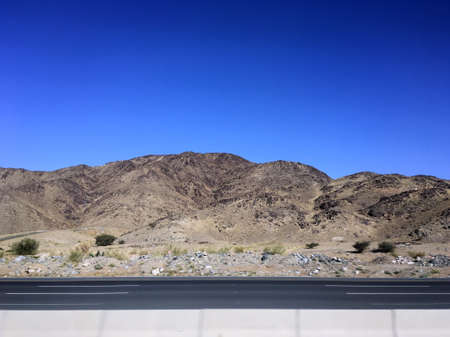 Wide angle view of highway road with hills and blue skyの写真素材
