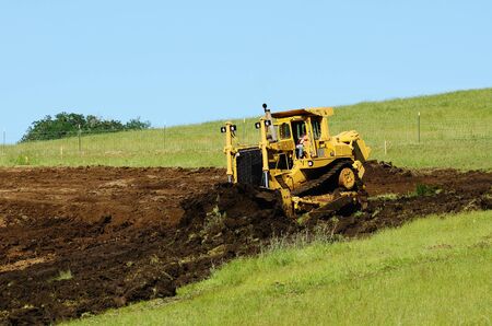 A large bulldozer grading a hillside in preperation for a major highway intersection project in Oregonの写真素材
