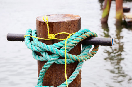 Small fishing vessel tied to the dock using blue rope