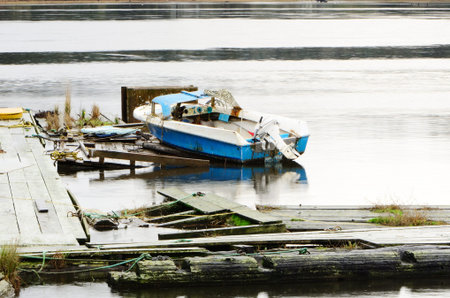 A small fishing boat on a deteriorated dock in Florence Oregonの写真素材