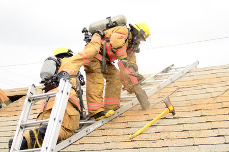 Roseburg, OR USA - July 21, 2011: Roseburg Fire Fighters participating in a vertical ventilation drill at a old hotel.のeditorial素材
