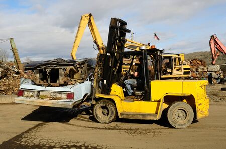 A large lift truck moving discarded autos for metal recyling.の写真素材