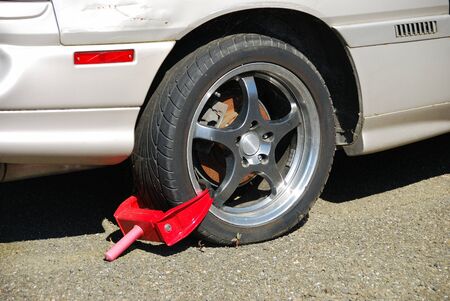 A boot placed on a car for failure to pay storage feesの写真素材