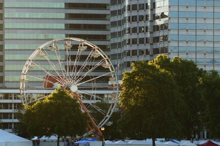 A colorful ferris wheel lights up against the city skyline of Portland Oregon during the Rose Festival CityFairのeditorial素材