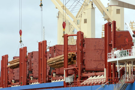 A large commercial ship being loaded with fir logs for export to Asia on the docks in Coos Bay and North Bend Oregonのeditorial素材