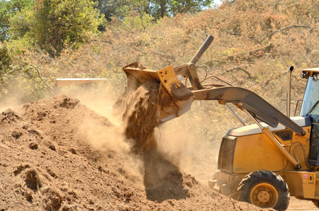 Small backhoe moves dirt at a new commercial construction development project