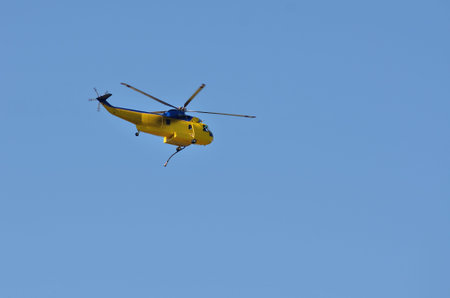 A fire fighting helicopter flies back to base after fighing fire in the Douglas Complex forest fires...