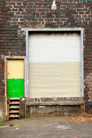 Garage door and mand entry to an warehouse in the industrial area of North Portland Oregonの写真素材