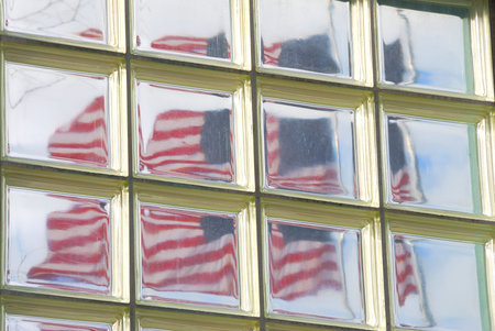 The american flag through a glass block window 