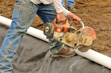  contractor installing a drainage system for a a wall using large concrete blocks to make a retaining wall at a new commercial construction projectの写真素材