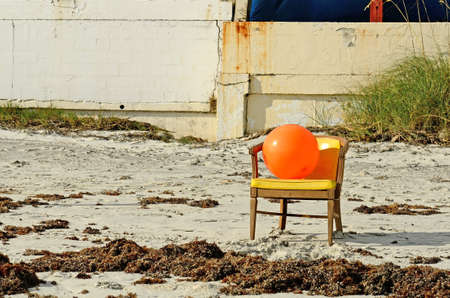 Orange beachball sitting in a chair on Daytona Beach Floridaの写真素材