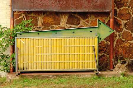 A old sign board with an arrow sits with no lettersの写真素材