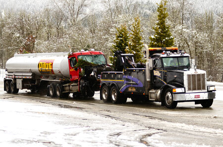 A tow truck hauls a truck and semi trailer following a fatal single vehicle accident during a recent snow storm, Canyonville Oregon, January 10, 2013のeditorial素材
