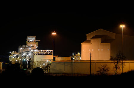 A large wood chip processing plant sits at the Port of Coos Bay, Oregon at night - wood chips are shipped to other countriesのeditorial素材