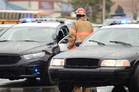 Emergency workers at the scene of a single car, rollover accident during a spring rain in Roseburg...