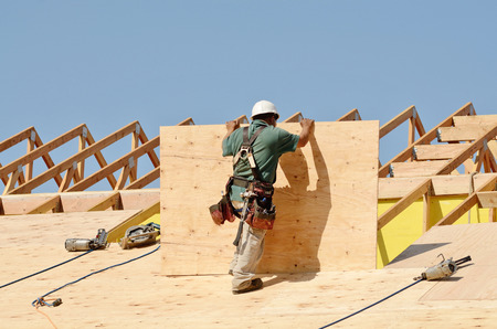 Construction crew working on the roof sheeting of a new, two story, commercial appartment building in Oregonの写真素材